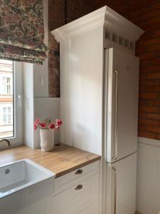 a kitchen with a white refrigerator and a sink at Anny Łajming 2D in Słupsk