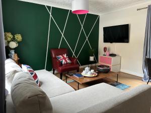 Parkside Stay in East Dulwich في لندن: غرفة معيشة مع أريكة بيضاء وجدار أخضر