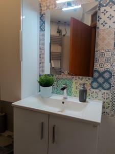 a bathroom with a sink and a mirror at Airport Family House in Artemida