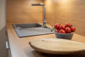 uma tigela de tomates sentados num balcão ao lado de um lavatório em Am Strande 31 Neptun em Neustadt in Holstein