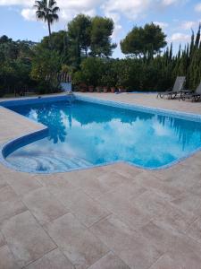 a swimming pool with blue water in a yard at Apartments in a "VILLA VISTA JAVEA" in Jávea