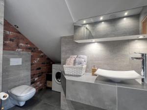 a bathroom with a sink and a washing machine at Apartament Bronowice 2 in Kraków