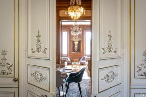 a hallway with a table and chairs and a chandelier at Le Champlain in La Rochelle