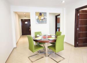 a dining room with a table and green chairs at RH-Prime Location , Spacious 1 Bedroom near Mall of the Emirates in Dubai