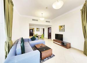 a living room with a blue couch and a tv at RH-Prime Location , Spacious 1 Bedroom near Mall of the Emirates in Dubai