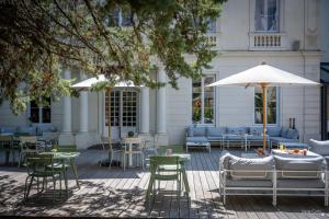 a patio with tables and chairs and an umbrella at Le Champlain in La Rochelle