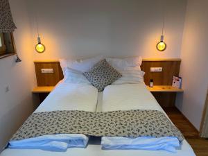 a large bed in a bedroom with two pillows at KRASTHAUS in Oberhaag