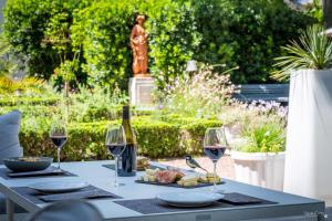 a table with wine glasses and cheese and a statue at Le Champlain in La Rochelle