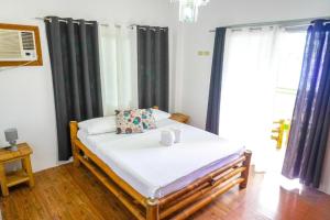 1 dormitorio con 1 cama con cortinas negras en Baki Divers and Beach Resort, en Dauin