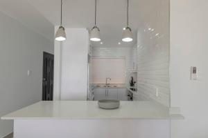 a white kitchen with a white counter and a sink at 17 Bronze Beach Umhlanga Rocks in Durban