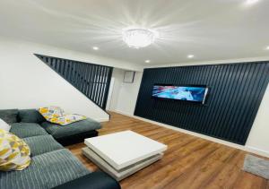 Luxury New Home في Kent: غرفة معيشة مع أريكة وتلفزيون