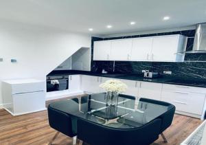 a kitchen with a glass table with a vase of flowers at Luxury New Home in Kent