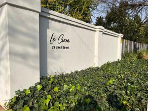 un mur blanc avec les mots le terrain de volley-ball dans l'établissement Le'Ciara Luxury Guest House, à Johannesbourg