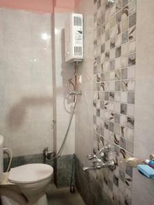 a small bathroom with a toilet and a shower at Masuti Homestay for Swami Bhakts AC room in Akalkot +3 photos