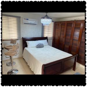 a bedroom with a bed and a chair and a chandelier at Apartment city center and cable car in San Felipe de Puerto Plata