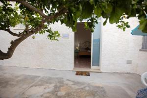 una puerta a una casa con un árbol en primer plano en SALUTAMU en Locogrande