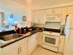uma cozinha com armários brancos e um lavatório em Spectacular Views in Bayfront Coconut Grove em Miami