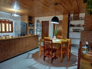 cocina y comedor con mesa y sillas en Casas Bueno en Camanducaia