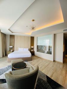 a hotel room with a bed and two chairs at Panorama Apartment Sunset Nha Trang City in Nha Trang
