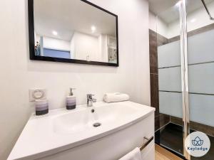 uma casa de banho com um lavatório e um espelho em Ti Paradis, 3 etoiles à deux pas du centre de Saint-Gilles em Saint-Gilles-les-Bains