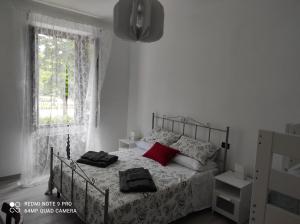 een slaapkamer met een bed met rode kussens en een raam bij Giravolta (Jaco) in Sulmona
