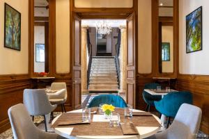 a restaurant with tables and chairs and a staircase at Le Champlain in La Rochelle