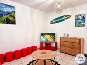 um quarto com cadeiras vermelhas, uma mesa e um armário em Ti Paradis, 3 etoiles à deux pas du centre de Saint-Gilles em Saint-Gilles-les-Bains
