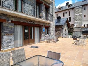 a patio with chairs and a table in front of a building at Apart. Casa Juaneta Pirineo-Ordesa in Broto