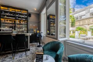 a bar with green chairs and a window at Le Champlain in La Rochelle