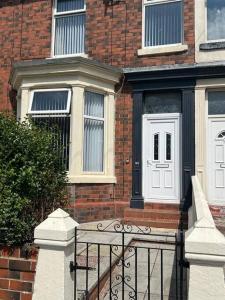 a brick house with a gate and a white door at No 33 Central Blackpool in Blackpool