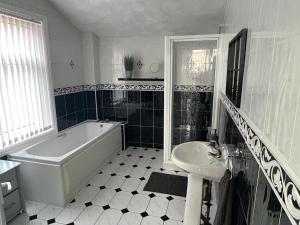 a black and white bathroom with a tub and a sink at No 33 Central Blackpool in Blackpool