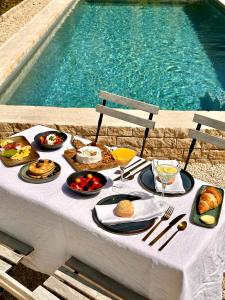 Hoeve La Cascina في دينزة: طاولة عليها طعام بجانب مسبح