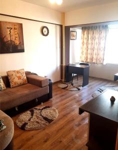 een woonkamer met een bank en een piano bij Mercur Studio Ploiesti in Ploieşti