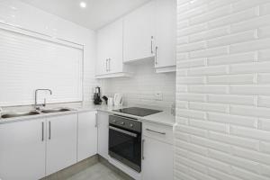 a white kitchen with a sink and a stove at 17 Bronze Beach Umhlanga Rocks in Durban