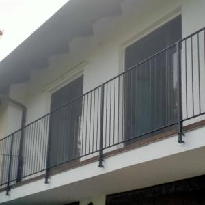 einen Balkon mit schwarzen Geländern in einem weißen Gebäude in der Unterkunft Da antonella in Cerretto Langhe