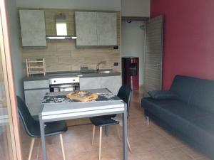 eine Küche mit einem Tisch, Stühlen und einem Sofa in der Unterkunft Da antonella in Cerretto Langhe