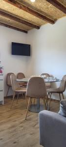 una sala da pranzo con tavolo, sedie e TV di Guest House MJ a Póvoa de Varzim
