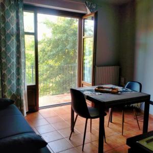 ein Esszimmer mit einem Tisch und einem großen Fenster in der Unterkunft Da antonella in Cerretto Langhe