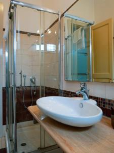 a bathroom with a sink and a glass shower at My Friend Antonia in Barcellona-Pozzo di Gotto