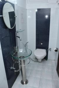 a bathroom with a glass sink and a toilet at AESTHETICS - THE HOME STAY in Shillong