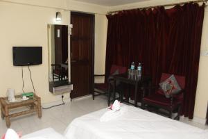 a hotel room with a bed and a television at AESTHETICS - THE HOME STAY in Shillong