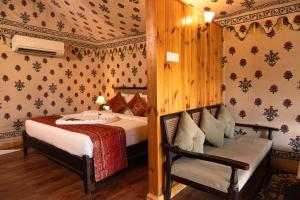 Un dormitorio con 2 camas y una silla. en Om Vilas Benares, en Varanasi