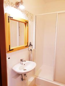 a bathroom with a sink and a mirror and a shower at Apartmán Terminál, self check-in 24 h in Banská Bystrica