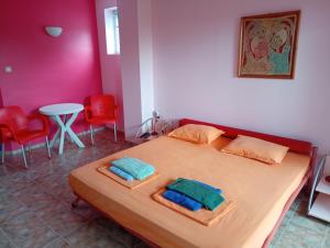 1 dormitorio con 1 cama con 2 toallas en The Colourful Mansion Hotel en Ahtopol