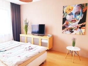a bedroom with a bed and a painting on the wall at Apartmán Terminál, self check-in 24 h in Banská Bystrica
