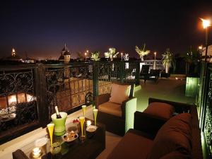 a balcony with a view of a city at night at Riad Carllian in Marrakesh