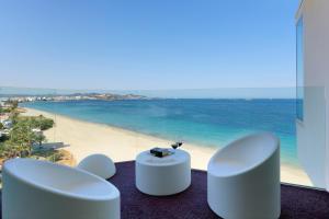 a view of a beach with two white chairs and a table at Hard Rock Hotel Ibiza in Playa d'en Bossa