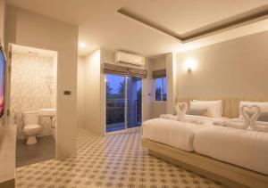 a bedroom with a large bed and a bathroom at Nature Pine Phuket เนเชอร์ไพน์ภูเก็ต in Rawai Beach