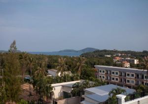 a view of a resort with palm trees and the ocean at Nature Pine Phuket เนเชอร์ไพน์ภูเก็ต in Rawai Beach