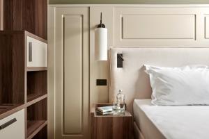 a bedroom with a bed and a table with a bottle on it at Maximilian Suites in Trieste